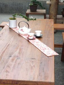 Solid wood table with floral teapots.
